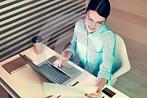 Top view of pretty office worker reading a printout