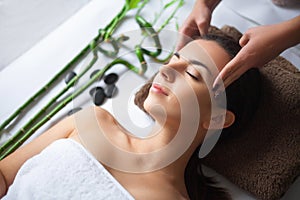 Top view of pretty woman laying in spa salon with closed eyes an