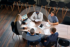 Top view of a pro business meeting in a modern office. Mixed race team with a female CEO discuss project strategies