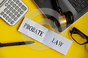 Top view of Probate Law text on white notepad with lawyer gavel, laptop, glasses and calculator background