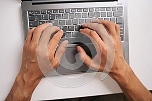 Top view of programmer male typing code on laptop keyboard, showcasing process of software development and coding