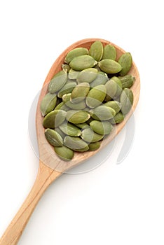 Top view of pumpkin seeds in wooden spoon