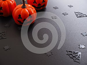 Top view of pumpkin, spiders and web shape on black grunge texture for halloween background