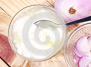 Top view of pure curd in a glass bowl with onion