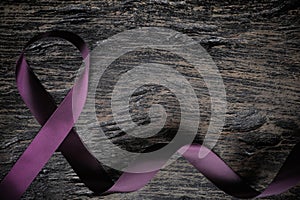Top view of purple ribbon on wood background with copy space. Pancreatic cancer, epilepsy, leiomyosarcoma, lupus, Alzheimer`s photo