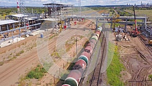 Top view of railway and station under construction. Clip. Freight train is standing on rails at platform under