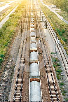 Top view of railway tracks with wagons with stone on summer day