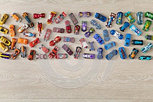 Top view random collection of model sport car toy hot wheels on wooden floor
