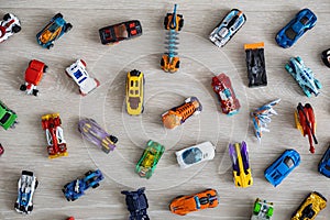 Top view random collection of model sport car toy hot wheels on wooden floor