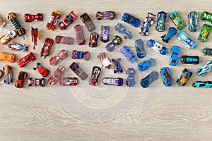 Top view random collection of model sport car toy hot wheels on wooden floor