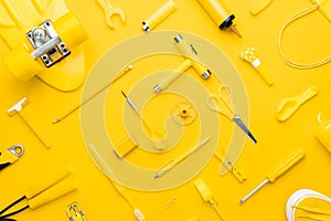 Top view of random yellow objects in order on yellow background