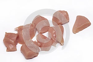 Top view of raw chicken fillet chunks on white