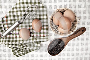 Top view of raw eggs in the basket and Straw or chaff with Egg beater , hand towel and rice berry