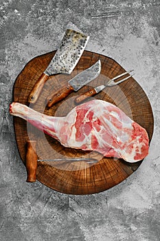 Top view of raw lamb shoulder chump on butcher`s cutting log