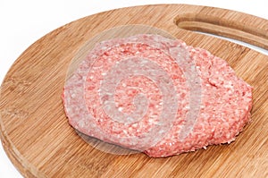 Top view of raw hamburger on wooden board prepared for roasting