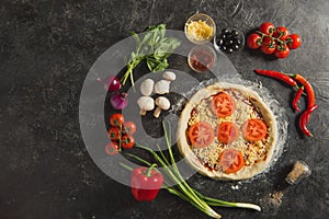 top view of raw italian pizza and fresh ingredients around