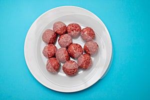 Top view of raw meat balls on small plate