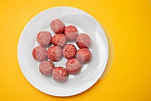 Top view of raw meat balls on small plate