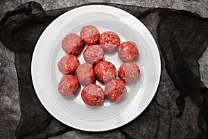 Top view of raw meat balls on small plate