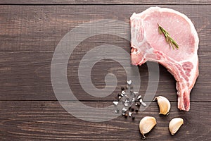 Top view raw pork chop steak and garlic, pepper, salt on wooden