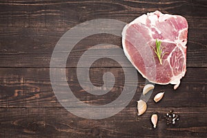 Top view raw pork chop steak and garlic, pepper on wooden background