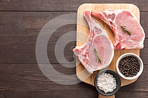 Crudo maiale cotoletta un aglio pepe sul di legno 