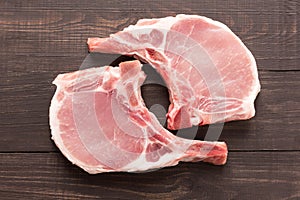 Top view raw pork chop steak on wooden background