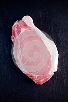 Top view raw pork loin steak on stone background