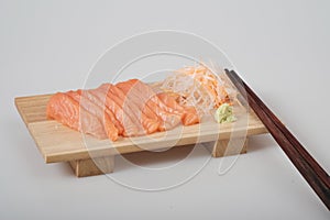 Top view raw salmon sashimi on wood board, and chopsticks