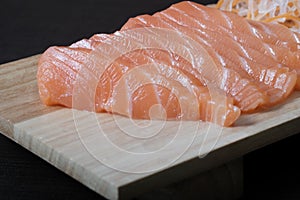 Top view raw salmon sashimi on wood board, chopsticks, and soup