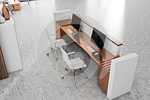 Top view of reception interior desk with two computers and pc screen