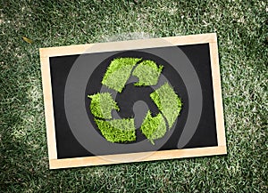 Top view of recycle symbol on blackboard with desaturated green