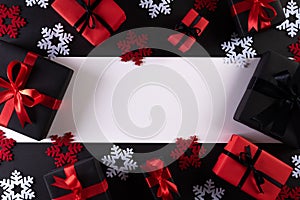 Top view of red and black christmas boxes on black background with copy space for text. black Friday composition