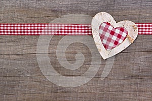 Top view of red checked heart decoration on wooden background -