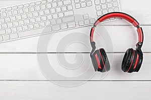 Top view of red headphone and white keybpard