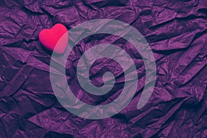 Top View Red Heart On Wrinkled Dark Purple Texture Background. Happy Valentine`s Day And Love Concept. Romantic Card, Banner