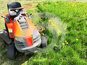 Top view of red lawn mower on garden field