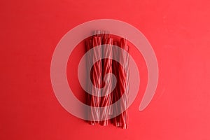 Top view of the red licorice sticks on a red background