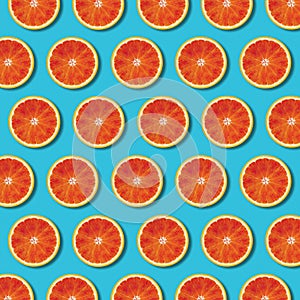 Top view red orange slices pattern on vibrant turquoise background