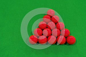 Top view of 15 red snooker balls on a green velvet floor snooker table