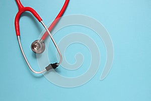 Top view of red stetoscope on blue background. Medicine concept.
