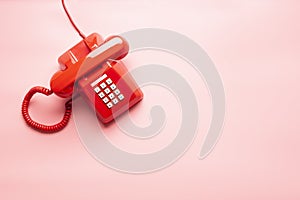 Red telephone on pink desk