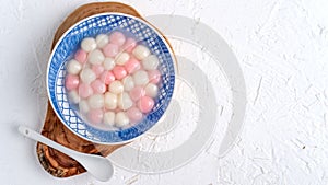 Top view of red and white tangyuan in blue bowl on white background for Winter solstice