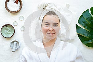 Top view of a relaxed woman with closed eyes having spa procedures using natural cosmetics