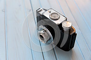 Top view of retro style camera on blue wooden table