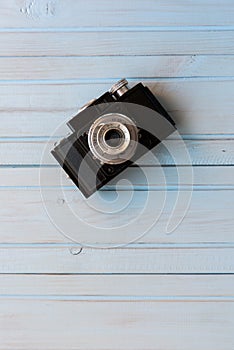 Top view of retro style camera on blue wooden table