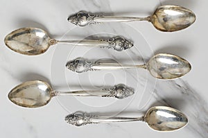 Top view of retro stylish spoons on the white table.Kit of vantage spoons