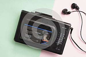 Top view of retro walkman on pink and green background