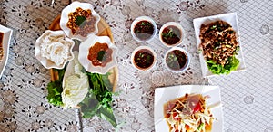 Top view of rice noodles with fresh vegetable and sweet sauce in wooden tray with spicy sauce