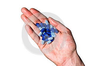 Top view of right, white, hand holding blue pills on white background